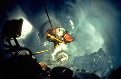 Recovery team members lowering themselves down the melted shaft. Recovery team members lowering themselves down the melted shaft.