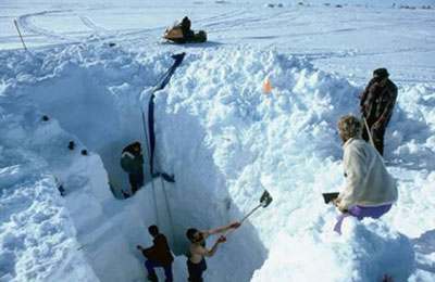 Hand excavation of snow at the surface to establish the start of the excavation shaft. Hand excavation of snow at the surface to establish the start of the excavation shaft.